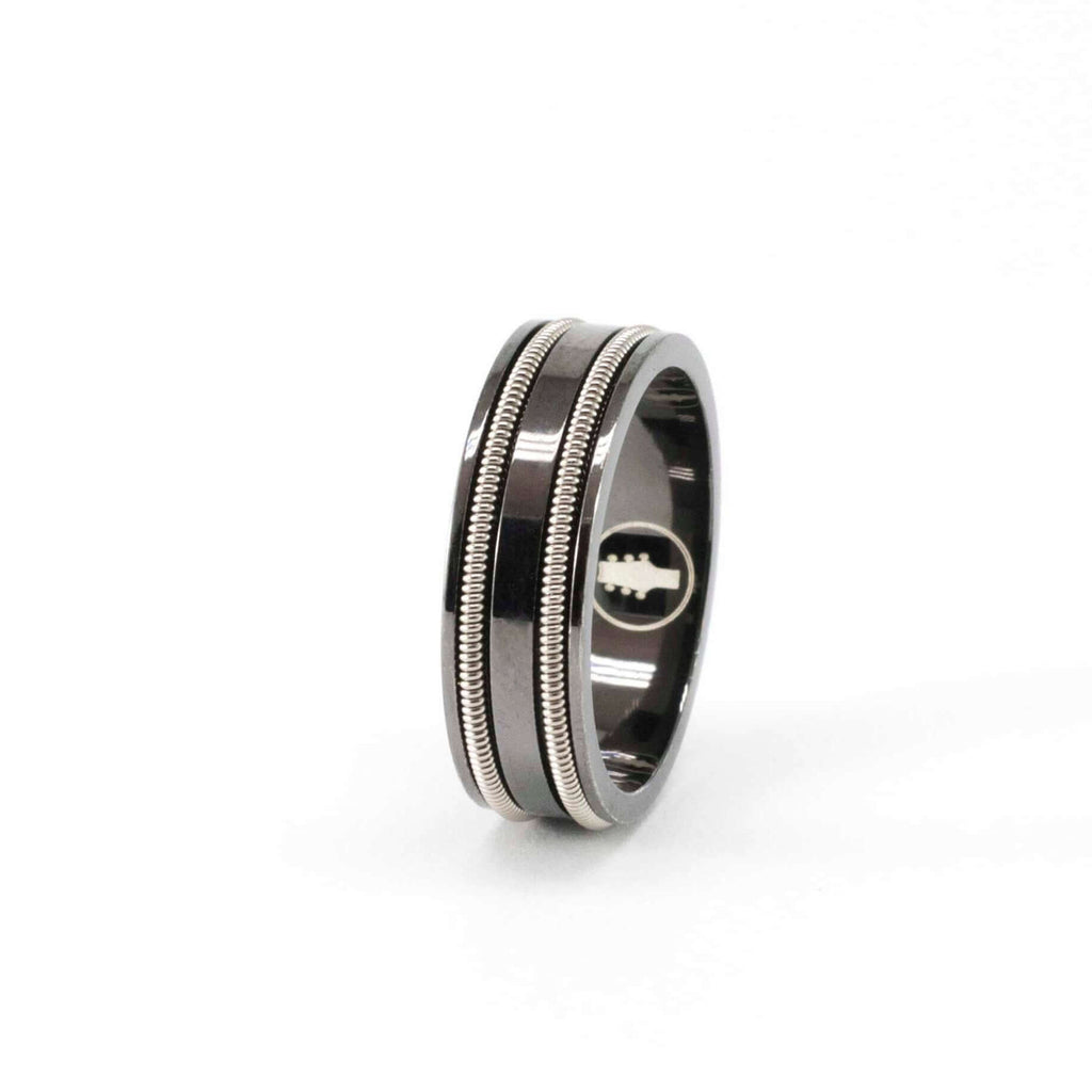 Black ring with two rows of embedded electric guitar string on a white background