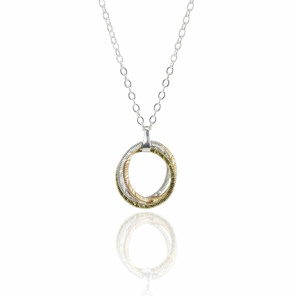 guitar string circular pendant on a silver chain suspended in a white background with reflection
