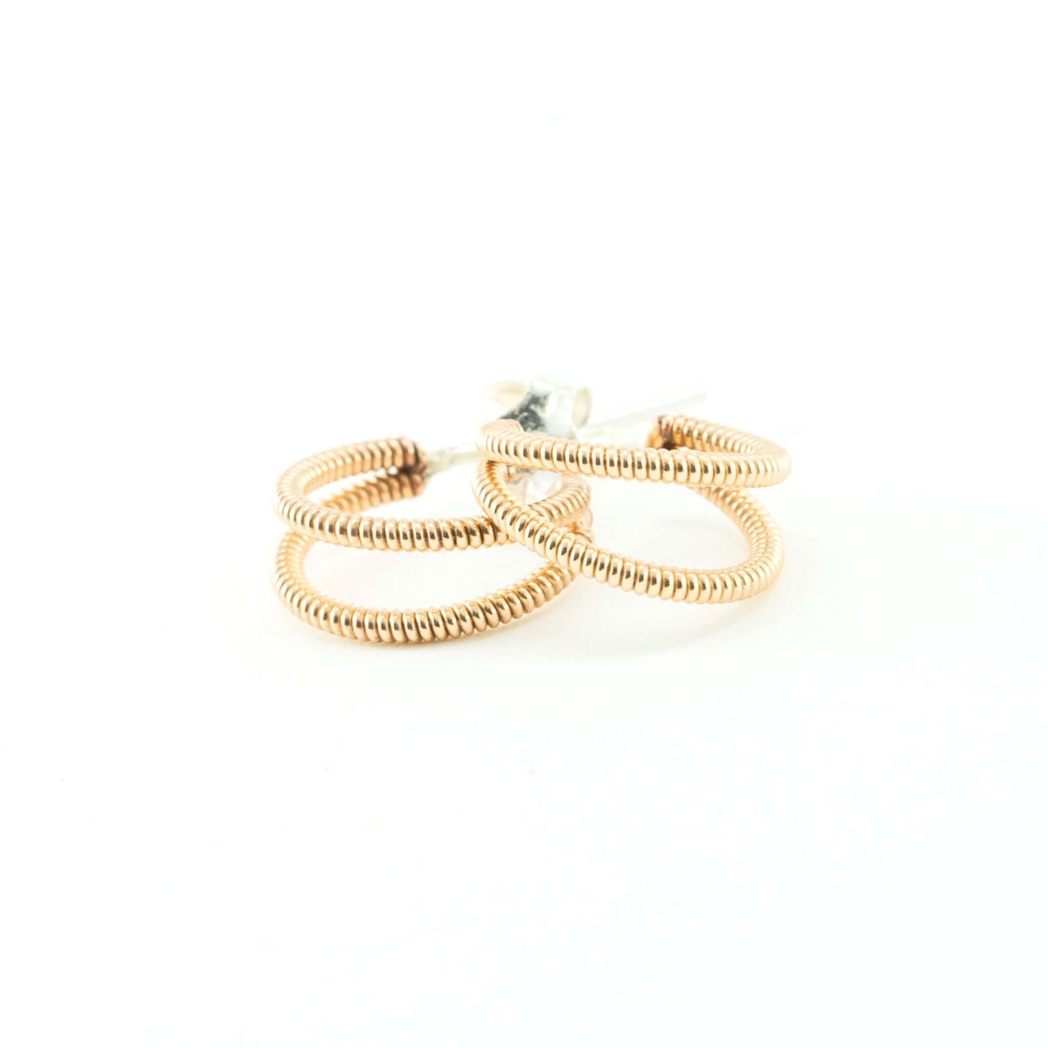 small crescent shaped acoustic guitar string earrings on a white background