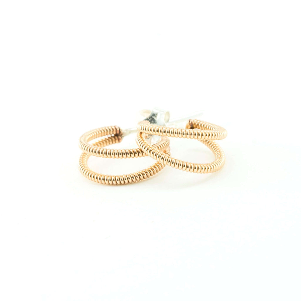 small crescent shaped acoustic guitar string earrings on a white background