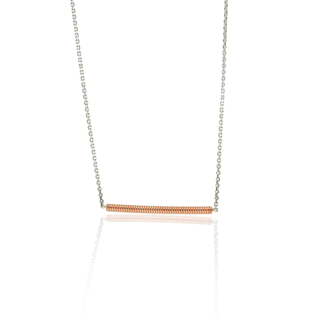 Piano string and white gold necklace on a whit background