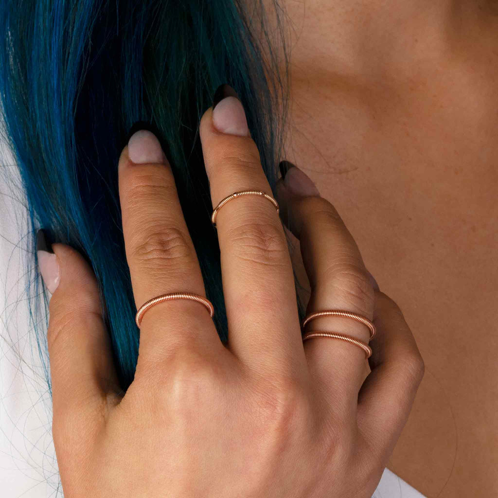 Piano and guitar string rings on model with blue hair and white top
