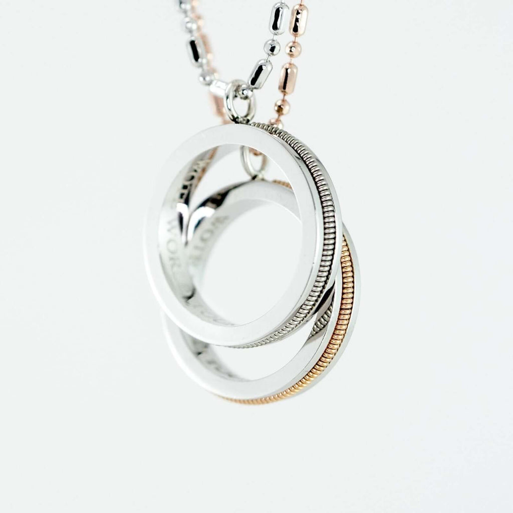 two guitar string and sterling silver round pendants on a silver and rose gold chain