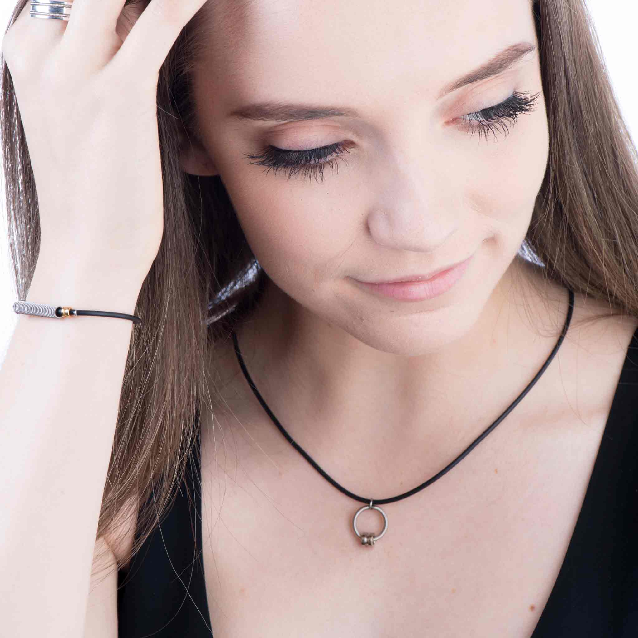 Urban electric guitar string jewelry collection on female model in black shirt and white background