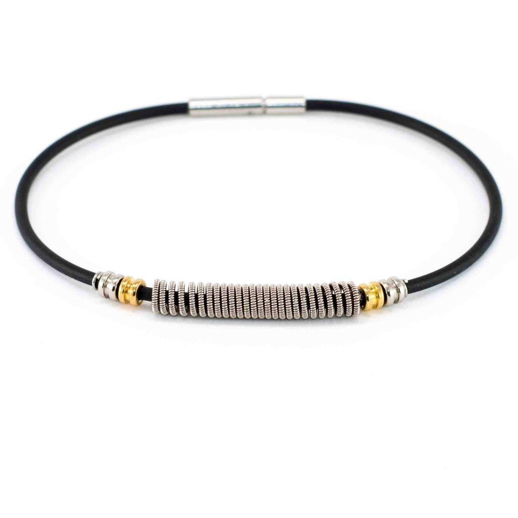 Black electric guitar string bracelet with silver and gold guitar ball ends on white background