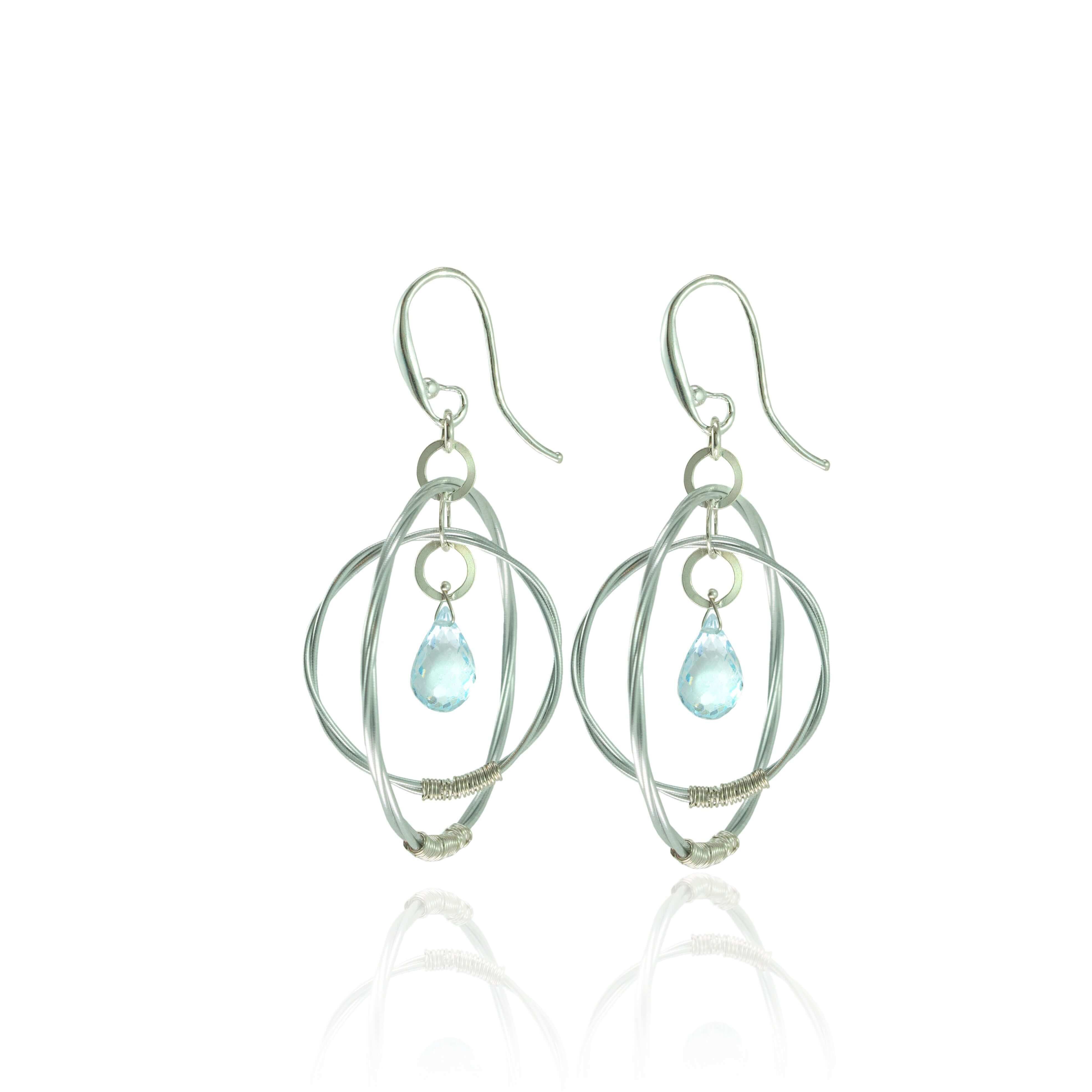 Violin string double hoop earrings with aquamarine gemstones on a white background